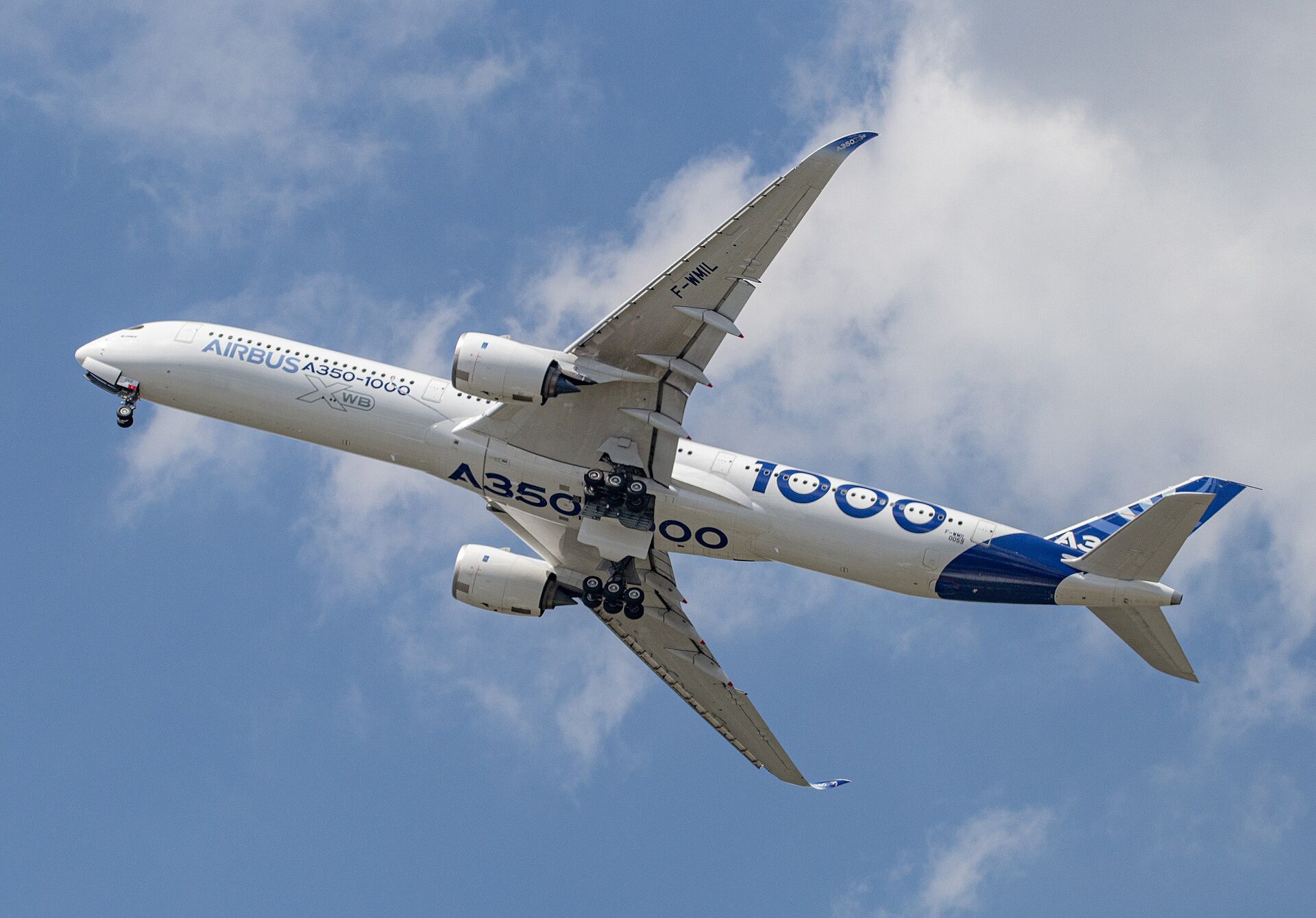 Airbus A350-1000 flying beneath broken cloud